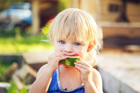 户外吃西瓜的可爱小女孩