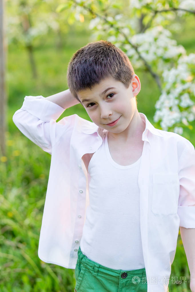 漂亮的小男孩在春天盛开的花园