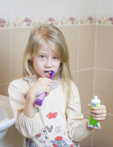 这个女孩她的牙齿，她手里拿着一种牙膏