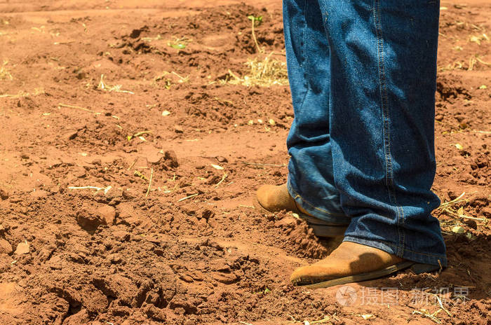 男人的腿在泥土地面上使用的靴子