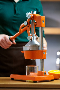 美丽的女人制作排毒汁从橙色与榨汁机