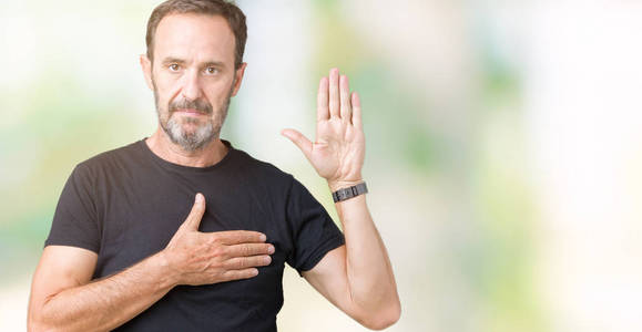 忠诚男性英俊的中年白衣老人在孤立的背景发誓用手在胸口和张开的手掌