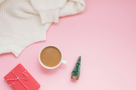 创意圣诞平躺在头顶上看到咖啡牛奶拿铁杯和礼物盒在千年粉红色的背景复制空间最小的风格。女性博客社交媒体的圣诞心情模板