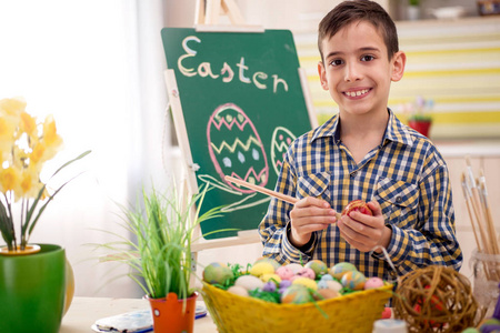 微笑的男孩绘制复活节彩蛋