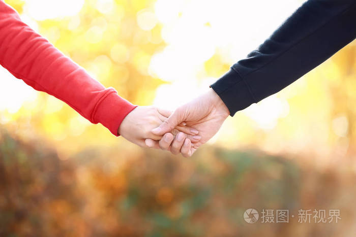 爱的年轻夫妇手牵手在户外