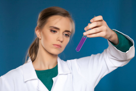 女化学家在蓝色背景上的测试管