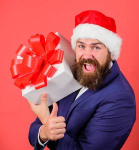 用礼物来传播快乐和幸福。男人留胡子的嬉皮士正式西服庆祝圣诞节。礼品服务理念。男人开朗拿着礼盒与节日丝带弓。就连成年人也对这样的礼