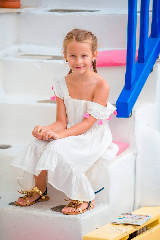 可爱的小女孩,在典型的希腊村庄的步