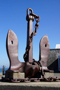 巨大的船锚老式生锈的锚和缠绕的锚,一个大的铁锚链抛出生锈的海岸.