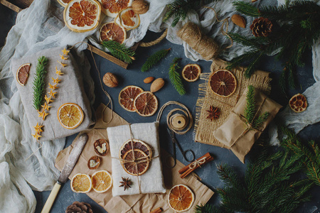 用用柠檬片装饰的麻布包裹的冷杉树枝和圣诞礼物