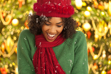 站在圣诞树前的快乐的年轻黑人妇女的画像