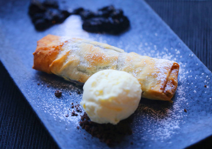 明亮的蓝莓派和冰淇淋在一个黑暗的盘子的宏观照片照片