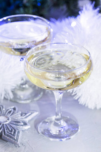 新年晚上, 优雅的一杯香槟酒, 白色和银色的金属丝, 花环和灯光周围