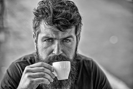 咖啡打破概念。长胡子的人看起来平静和放松。有胡子的人拿着咖啡杯, 喝咖啡。人与胡子和胡子在镇静宽松面孔, 轻的背景, 弥散