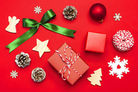 圣诞作文。新年的木制玩具, 冷杉锥, 红球, 雪花, 礼品缠绕在红色背景平躺顶部视图复制空间。圣诞冬季装饰自然新年概念