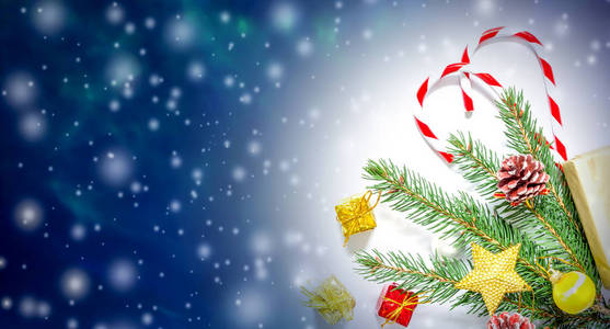 美丽的圣诞节和新年的背景与圣诞树树枝, 玩具和糖果, 飘落的雪和自由空间的文字