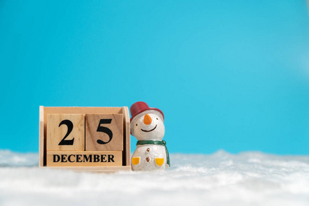 12月25日圣诞节期间, 戴着红帽子的雪人坐在玉块日历旁边, 上面有白色