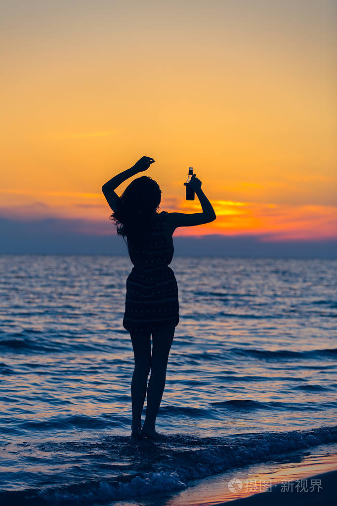 日出时在海滩上的性感女人