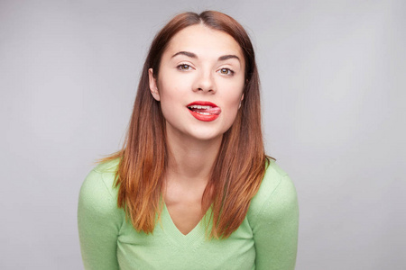 俏皮的女人看着相机, 咬舌头, 有快乐的样子, 和男朋友玩, 穿着休闲