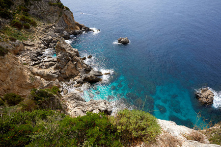 美丽的海景与绿松石水, 悬崖和大海。阳光明媚温暖的热带天气。在地中海旅行的背景。希腊。欧洲