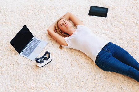该名女子躺在地毯上附近数码产品