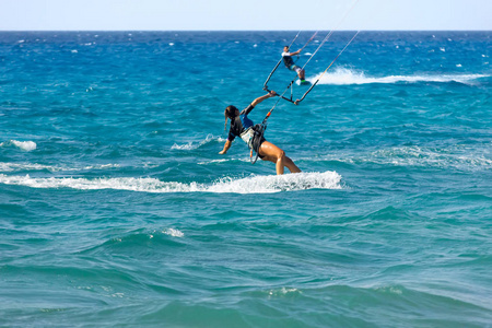 年轻女人风筝冲浪者骑在夏季的一天