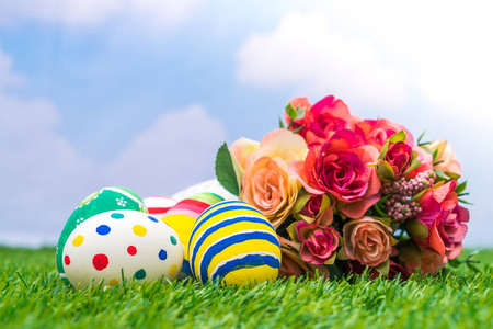 复活节彩蛋与新鲜的绿色草地上的人造花