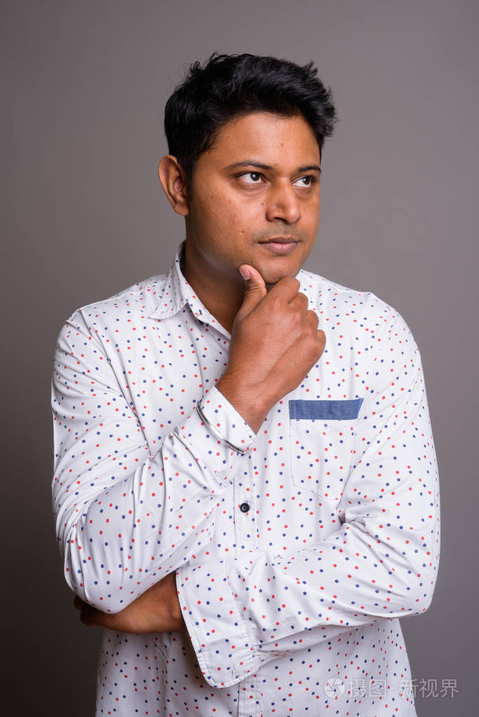 灰色背景下的年轻印度商人肖像照片-正版商用图片0tw22c-摄图新视界