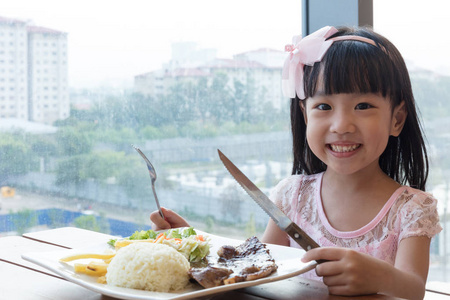 微笑亚洲中国小女孩吃羊肉牛肉饭