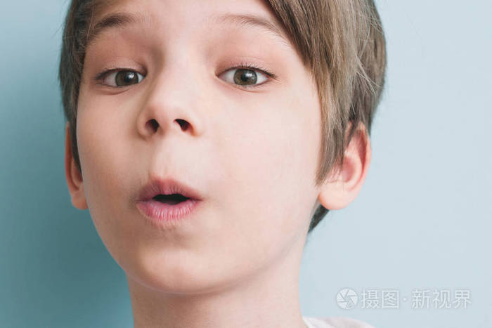 惊讶的男孩吹口哨, 看着相机.情感概念