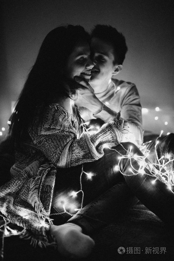 相爱的情侣在卧室的花环上互相拥抱.黑白照片, 带噪音过滤器