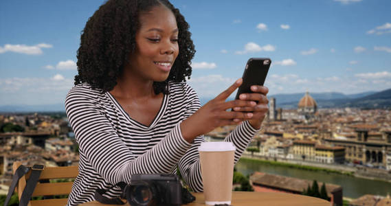 快乐的游客享受美丽的意大利城市的景色使用手机