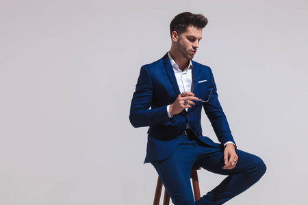 模特坐着坐着优雅的时装模特正俯视着灰色的背景照片