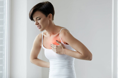 美丽的女人患有胸部疼痛.健康问题照片