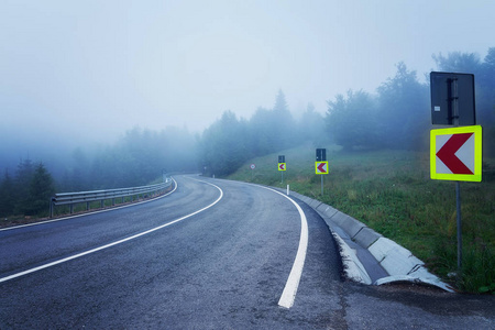 穿过雾蒙蒙的山的现代双线道路图片