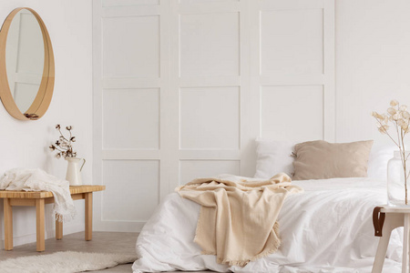 白色简约的卧室设计与镜子, 梳妆台和舒适的床与白色床单, 真实的照片