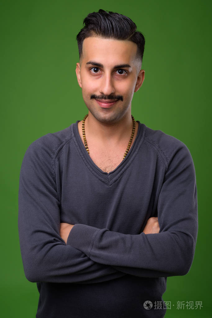 年轻英俊的伊朗男子与胡子对绿色背板