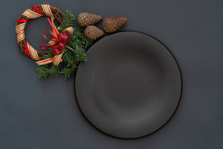 黑色盘子和老式餐具与圣诞装饰在黑色石头