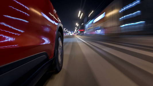 在城市的一条夜航大道上, 从快速行驶的汽车上看着快速行驶的城市, 道路上的灯光在高速上反射在汽车上。现代城市的快速节奏