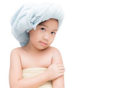 可爱的小女孩在她头上的毛巾应用身体霜