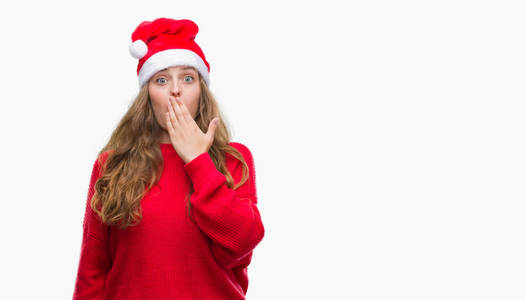 年轻的金发女子戴着圣诞老人帽子盖嘴与手震惊与羞愧的错误, 表达恐惧, 害怕在沉默中, 秘密概念