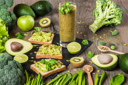 健康的绿色食品.纯素食三明治配牛油果和蔬菜上木制的背景.排毒饮食.