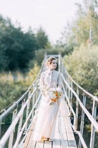 美丽的新娘在婚礼拱门前与鲜花和装饰。花束在手和细节。这个女孩很高兴, 微笑和跳舞。梦幻婚纱礼服的现代风格