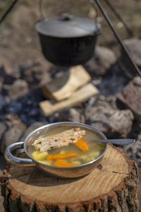 在火上做饭。火上的鱼汤。火上大锅里的食物。户外食物。在户外烹饪。在大锅上烹饪大自然