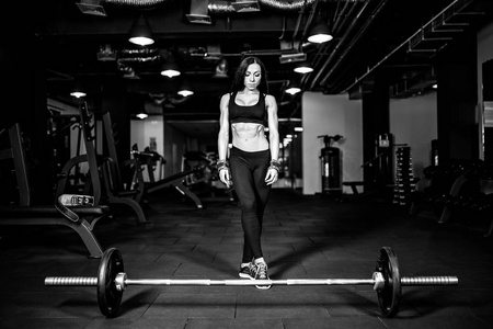 肌肉的年轻健身女人准备重肌肉锻炼在健身房