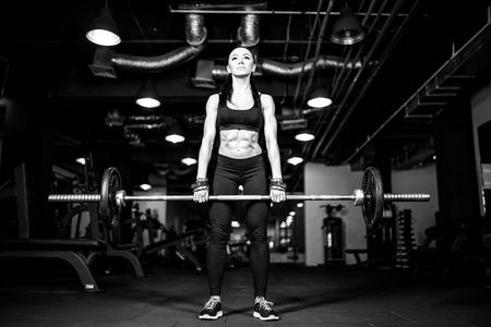 在健身房锻炼重肌肉的肌肉年轻健身女人