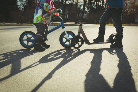 孩子们在日落时骑自行车和滑板车