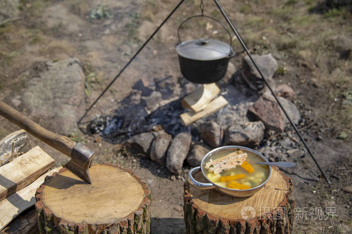 在火上做饭.火上的鱼汤.火上大锅里的食物.户外食物.在户外烹饪.