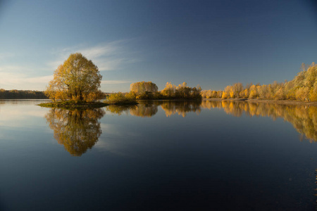 柔和的秋景, 在温暖的日子里, 在平静的水中反射