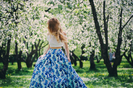 走在春天的花香马克西裙子漂亮的年轻女人
